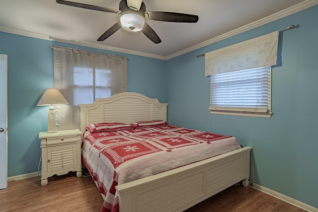 bedroom featuring multiple windows, ceiling fan, crown molding, and hardwood / wood-style flooring