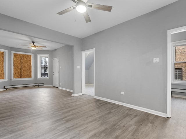 spare room with ceiling fan, light hardwood / wood-style floors, and a baseboard radiator