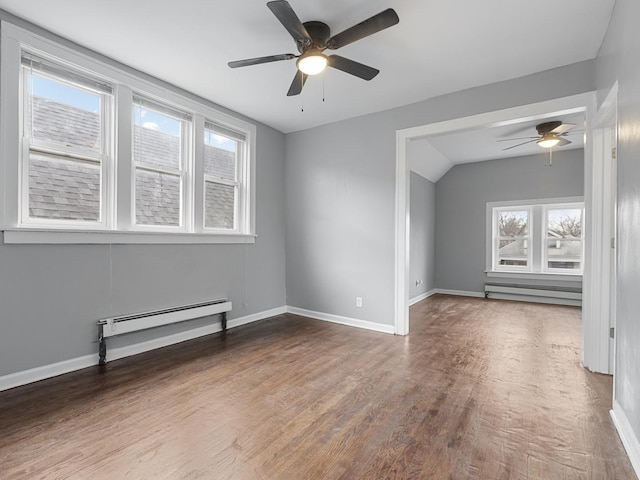 empty room with wood-type flooring, baseboard heating, lofted ceiling, and ceiling fan