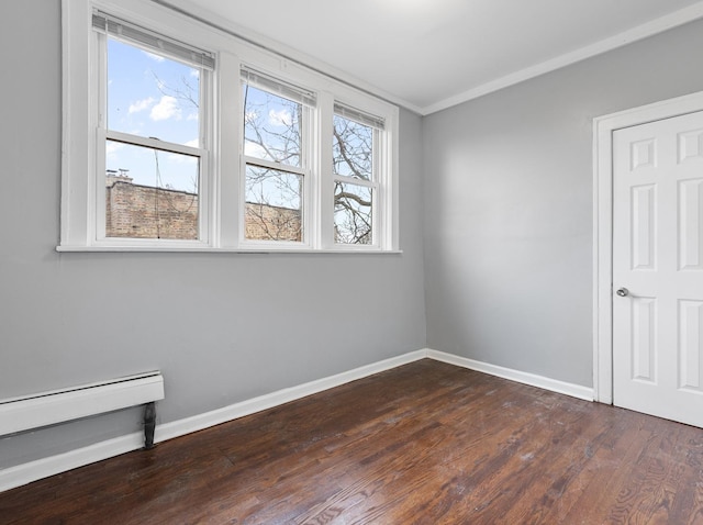 spare room featuring crown molding and dark wood-type flooring