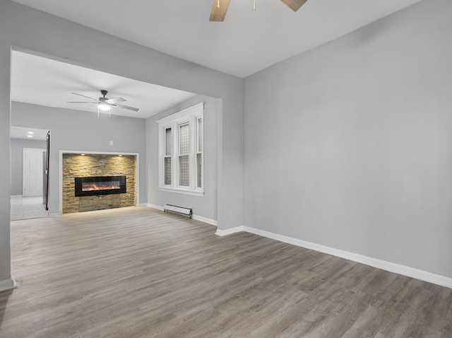 unfurnished living room featuring light hardwood / wood-style flooring, baseboard heating, and ceiling fan