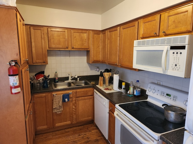 kitchen featuring backsplash, sink, white appliances, and dark hardwood / wood-style flooring