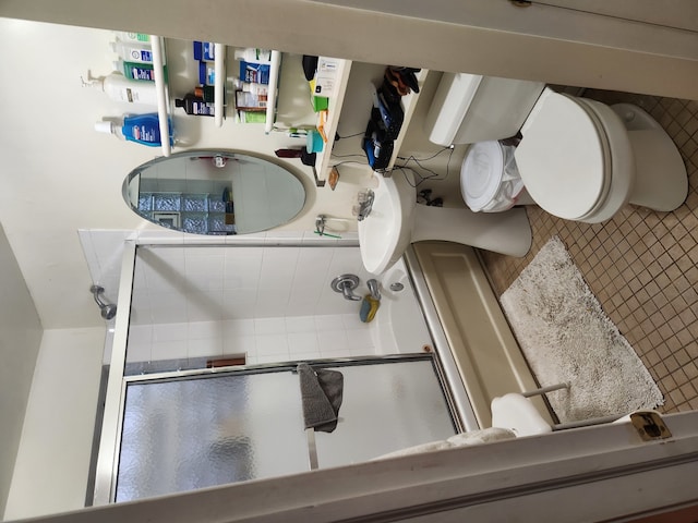 bathroom with toilet and an enclosed shower