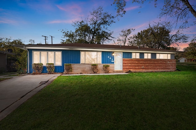 ranch-style home with a yard