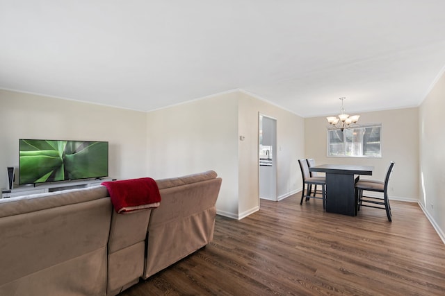 living room featuring crown molding, dark hardwood / wood-style flooring, and a chandelier