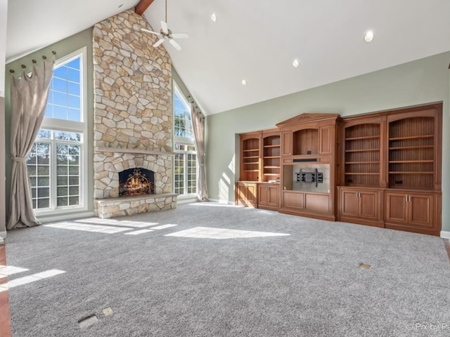 unfurnished living room with beamed ceiling, a fireplace, carpet floors, and ceiling fan