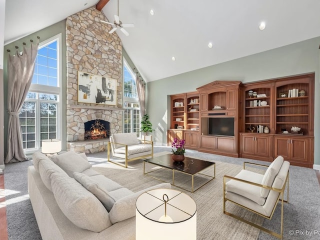 living room featuring a wealth of natural light, a stone fireplace, and light colored carpet