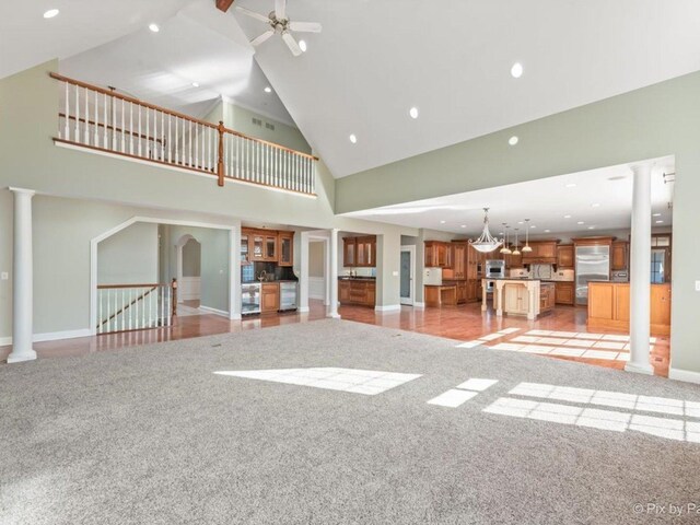 239 Indian Trail Rd, North Barrington, IL 60010 - unfurnished living room with ornate columns, recessed lighting, high vaulted ceiling, baseboards, and light colored carpet
