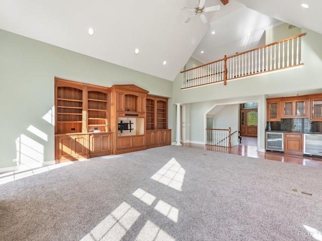 239 Indian Trail Rd, North Barrington, IL 60010 - unfurnished living room with beverage cooler, high vaulted ceiling, carpet, bar area, and baseboards