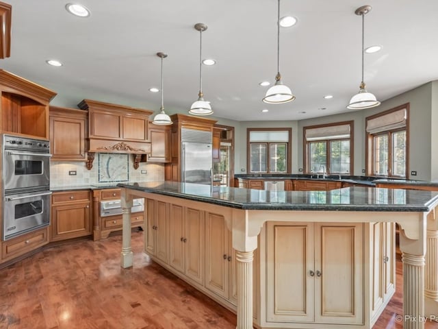 kitchen featuring pendant lighting, appliances with stainless steel finishes, hardwood / wood-style flooring, and a kitchen island