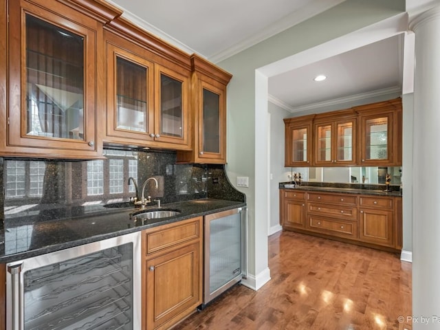 kitchen featuring hardwood / wood-style floors, sink, dark stone countertops, and beverage cooler