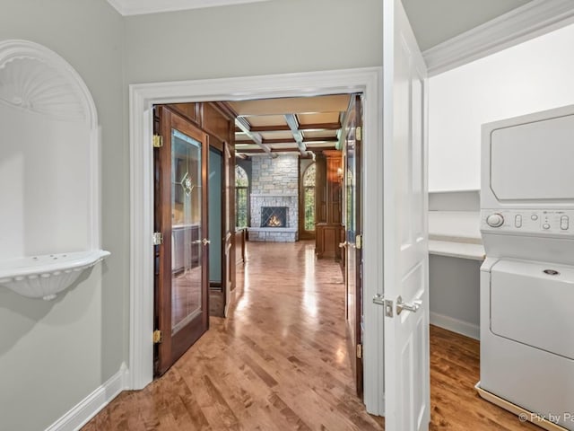interior space featuring light hardwood / wood-style floors, stacked washer / drying machine, and a fireplace