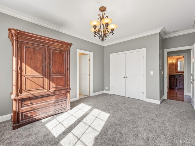 unfurnished bedroom featuring a chandelier, crown molding, carpet flooring, and a closet