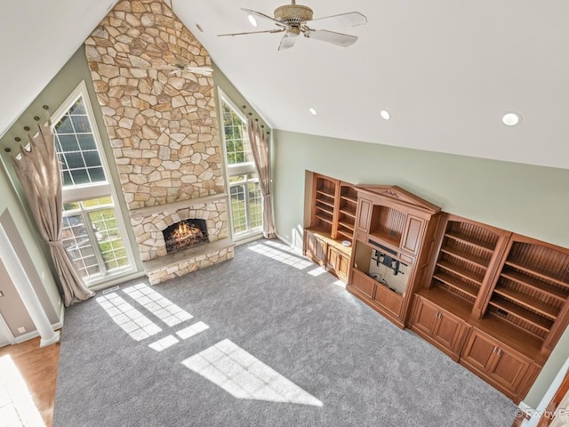 unfurnished living room featuring a fireplace, vaulted ceiling, plenty of natural light, and ceiling fan