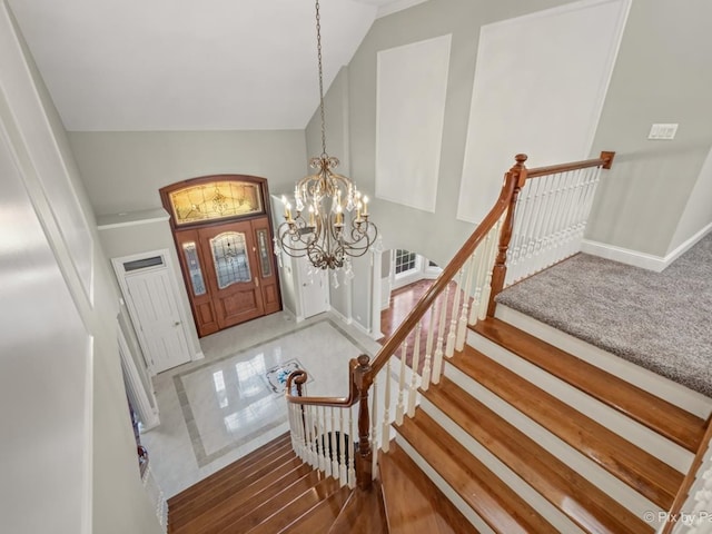 entrance foyer with an inviting chandelier, hardwood / wood-style floors, and high vaulted ceiling