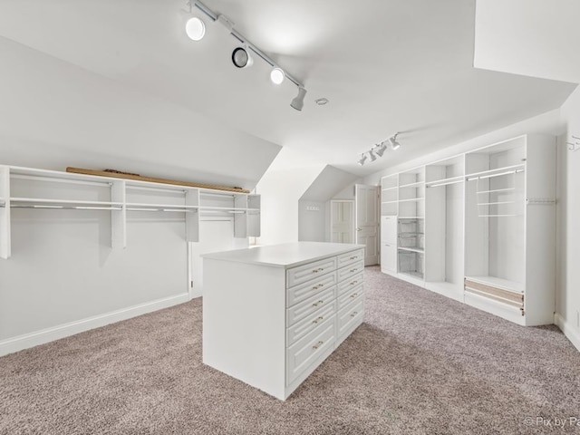 spacious closet with vaulted ceiling and light carpet