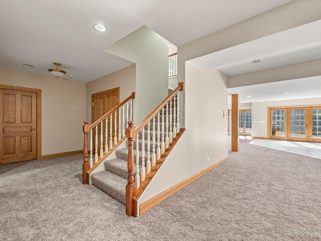 staircase featuring carpet