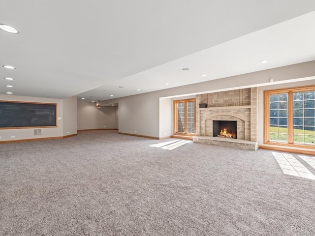 unfurnished living room with carpet floors and a brick fireplace