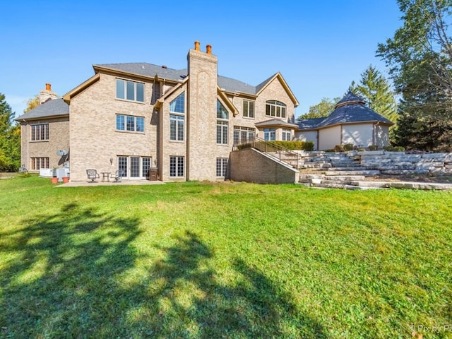 rear view of house featuring a patio and a lawn