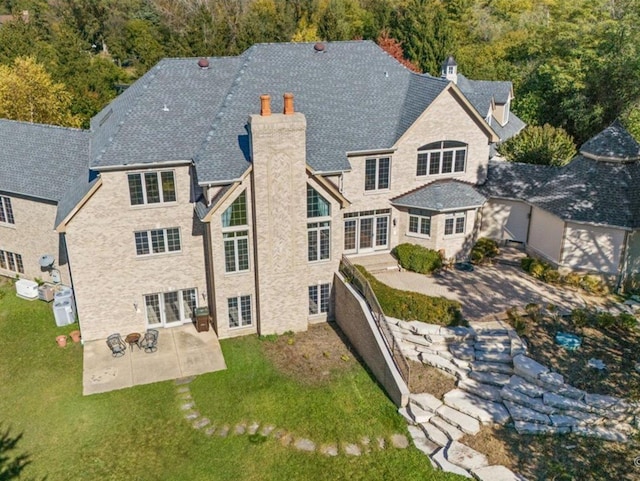 239 Indian Trail Rd, North Barrington, IL 60010 - back of house featuring a chimney, a patio area, and a yard