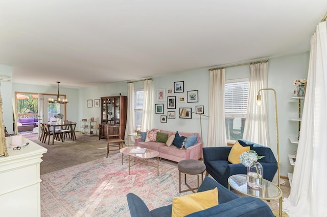 carpeted living room featuring plenty of natural light and a chandelier