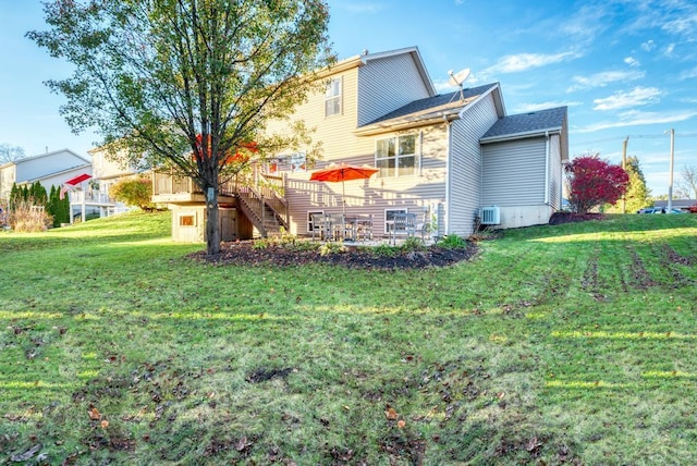 rear view of property with a wooden deck and a yard