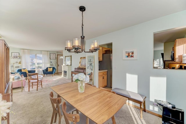 dining area with an inviting chandelier and light carpet