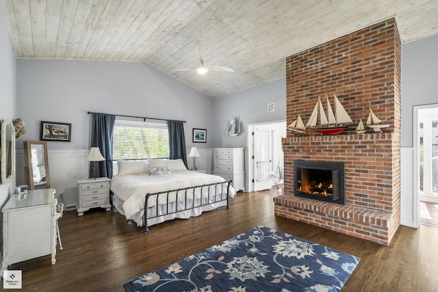bedroom featuring a brick fireplace, a ceiling fan, wood ceiling, wainscoting, and wood finished floors