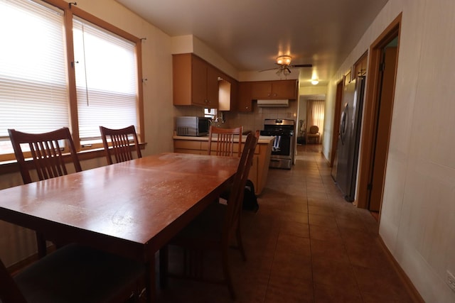 tiled dining area with ceiling fan