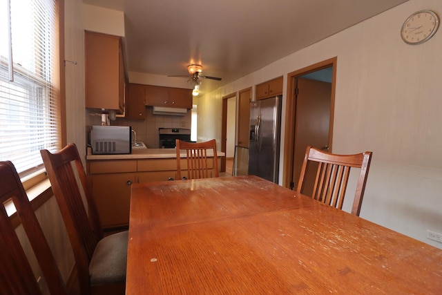 dining space featuring a fireplace and ceiling fan