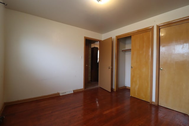 unfurnished bedroom with dark wood-type flooring