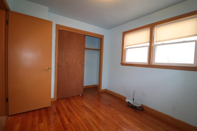 unfurnished bedroom with a closet and hardwood / wood-style flooring