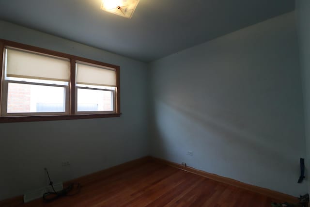 spare room featuring hardwood / wood-style floors and a baseboard radiator