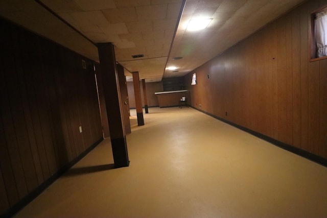 basement featuring wooden walls