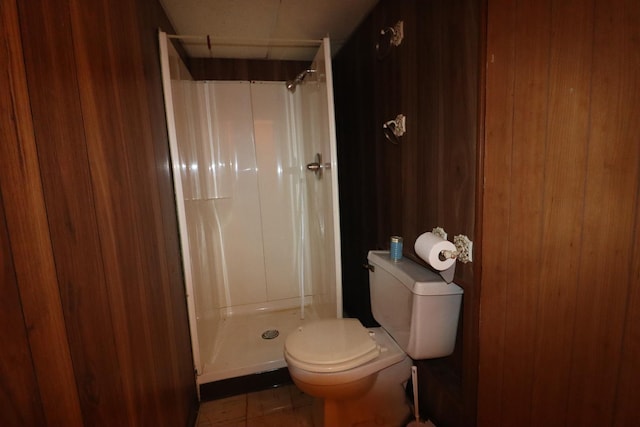 bathroom featuring tile patterned floors, toilet, and a shower