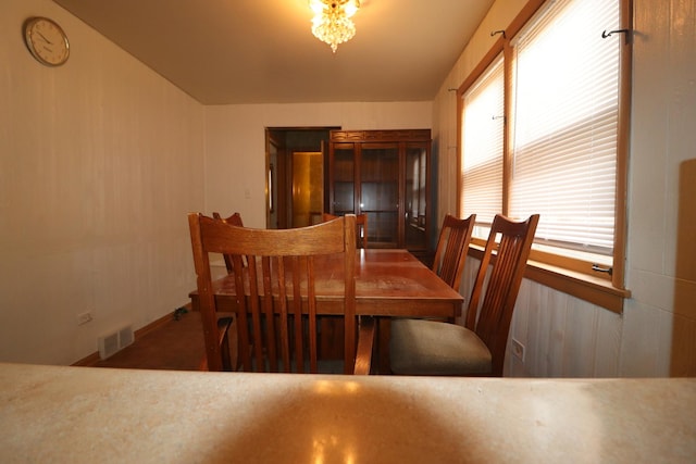 dining room featuring a wealth of natural light and dark carpet