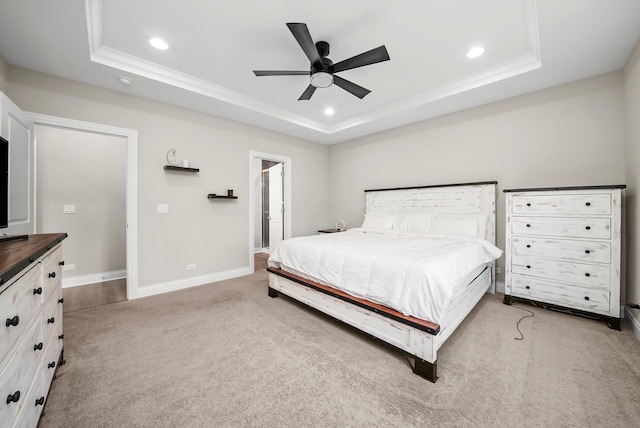 carpeted bedroom with ceiling fan and a raised ceiling