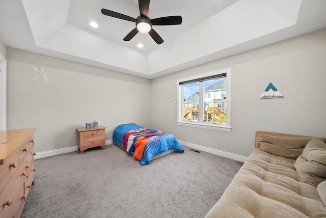 bedroom with carpet, ceiling fan, and a raised ceiling