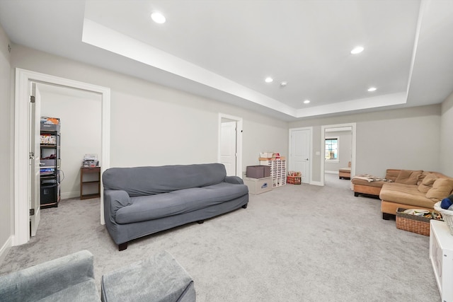 carpeted living room featuring a tray ceiling