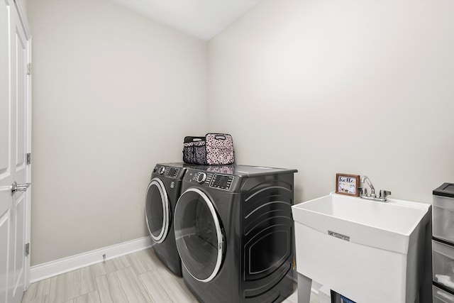 clothes washing area featuring washer and clothes dryer and sink