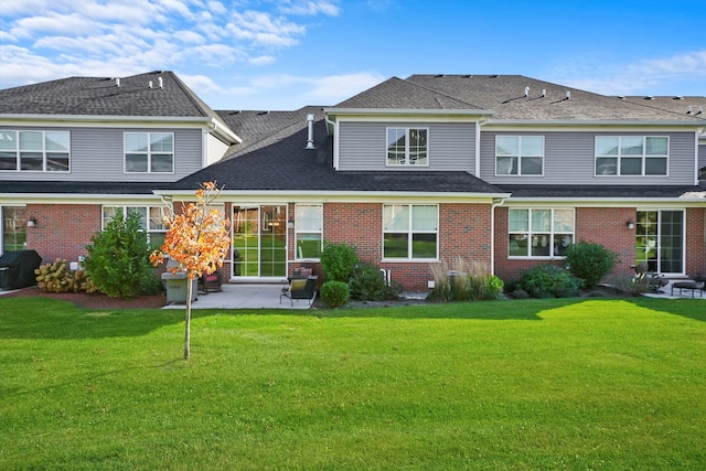 rear view of house with a patio area and a lawn