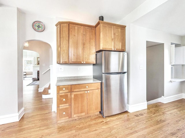 kitchen with stainless steel fridge and light wood-type flooring