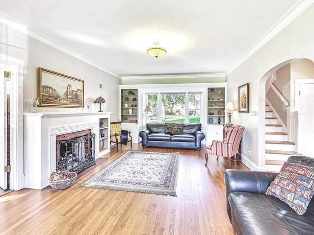 living room with ornamental molding, hardwood / wood-style flooring, and built in features