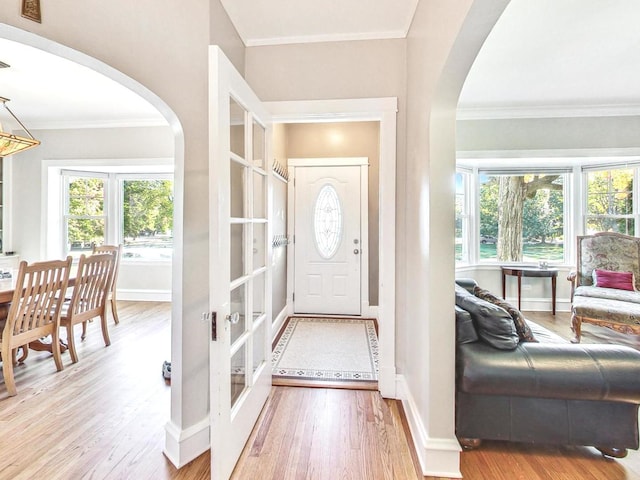 foyer featuring french doors, ornamental molding, and wood-type flooring