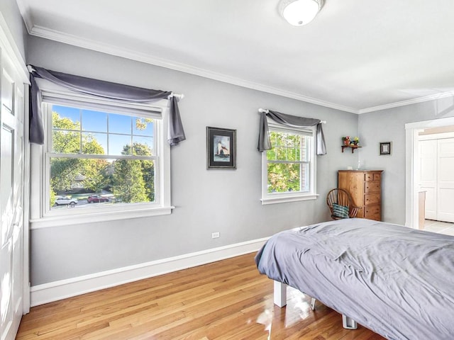 bedroom featuring ornamental molding and light wood-type flooring