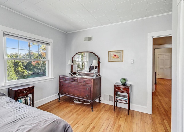 bedroom featuring ornamental molding and light hardwood / wood-style flooring