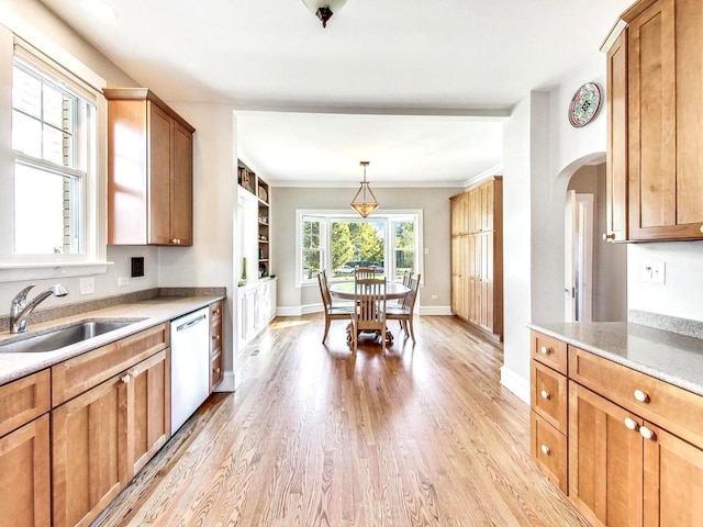 kitchen featuring white dishwasher, sink, crown molding, pendant lighting, and light hardwood / wood-style floors