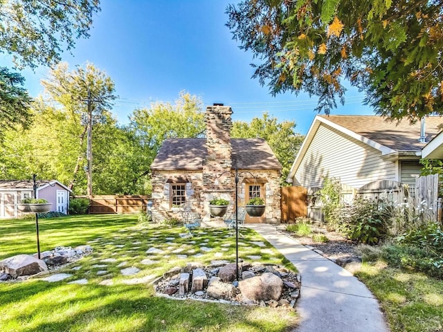 view of front of property featuring a front yard and a storage shed