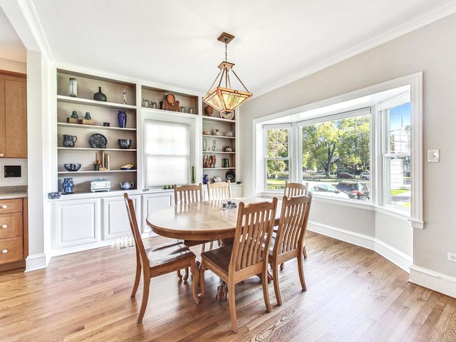 dining space featuring light hardwood / wood-style floors and crown molding