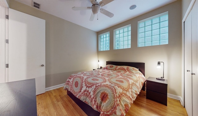 bedroom with light hardwood / wood-style flooring, a closet, and ceiling fan